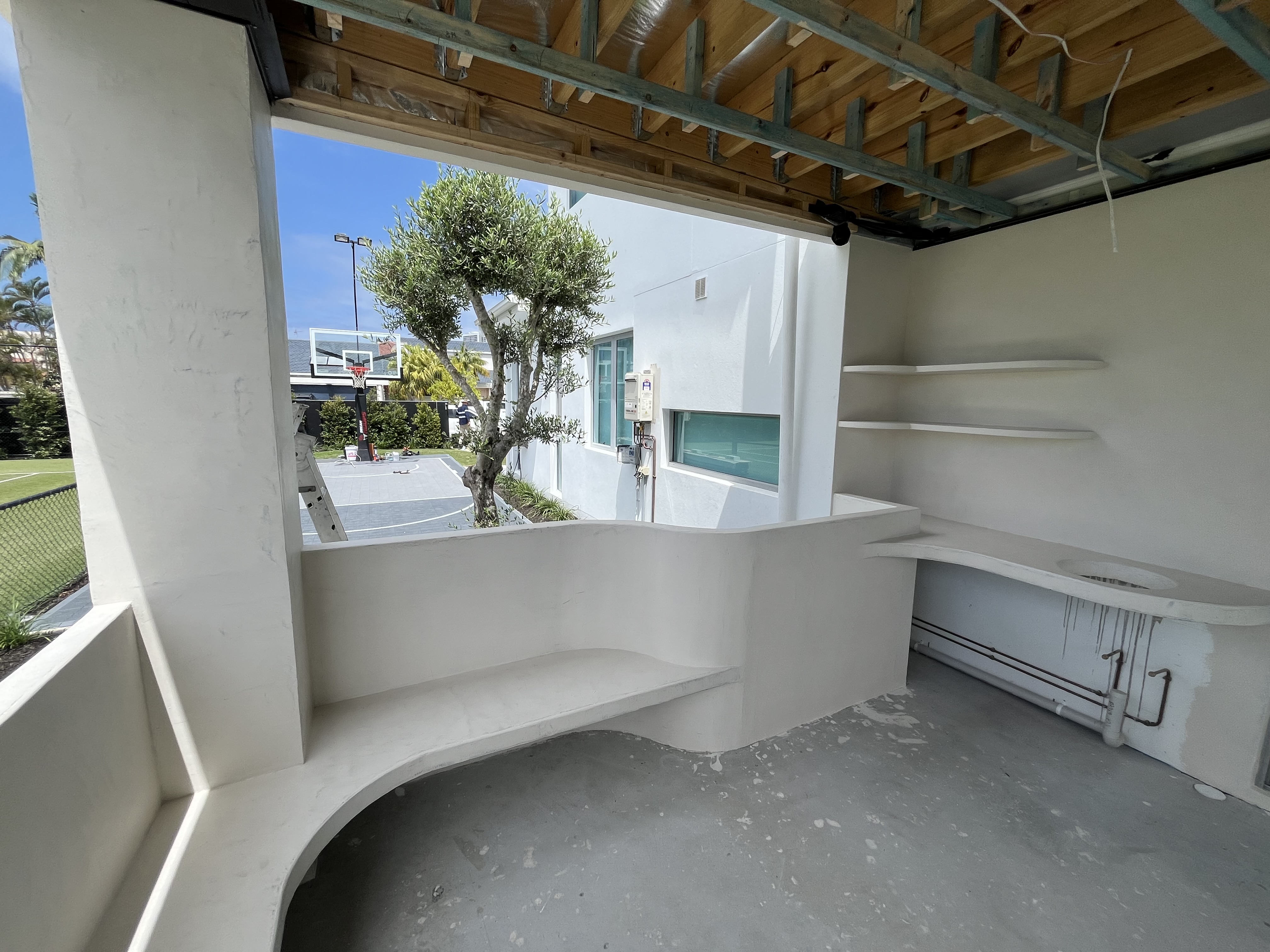 Curved bar and integrated shelving during microcement construction