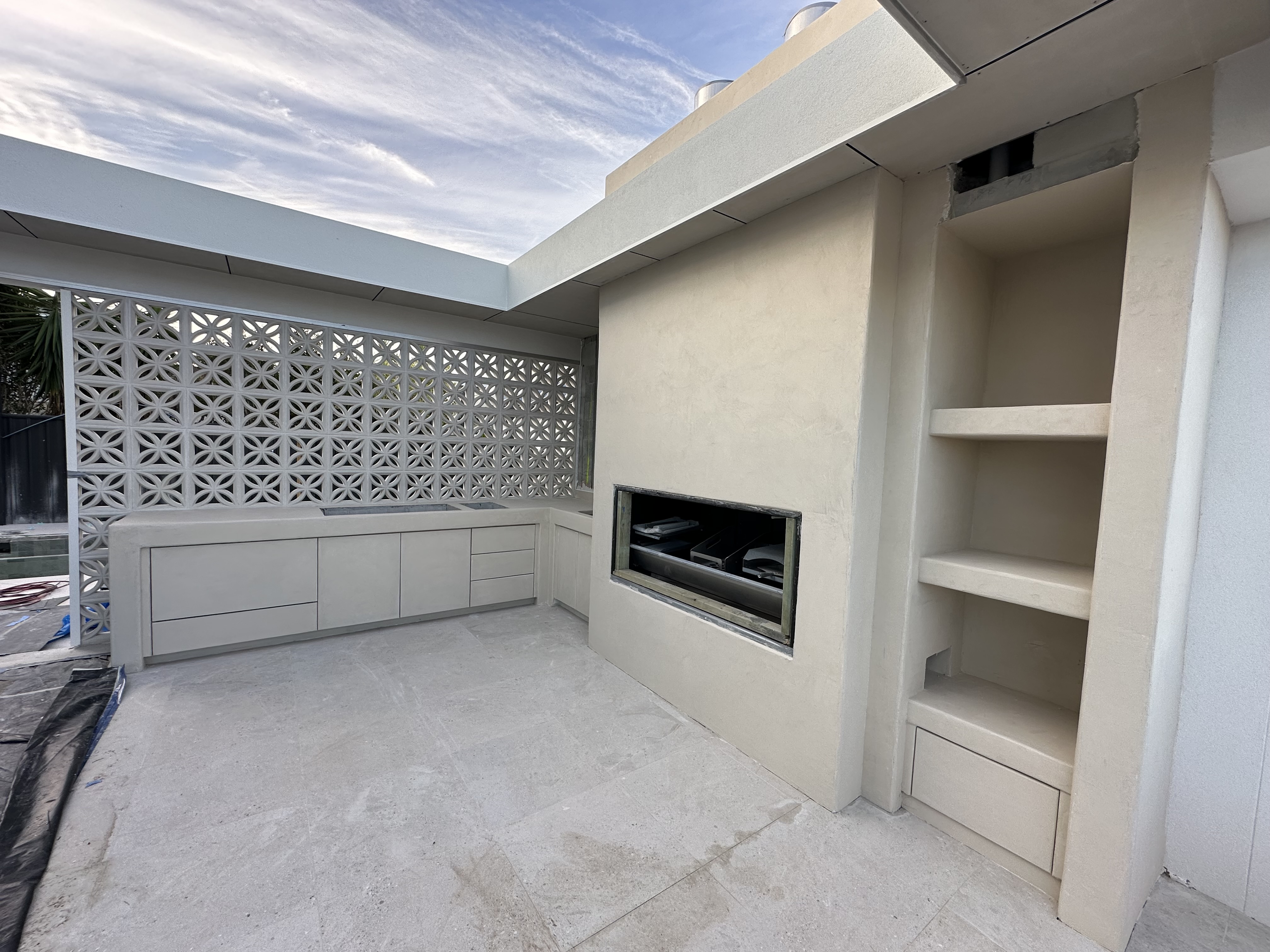 Outdoor curved microcement joinery and fireplace surround during construction