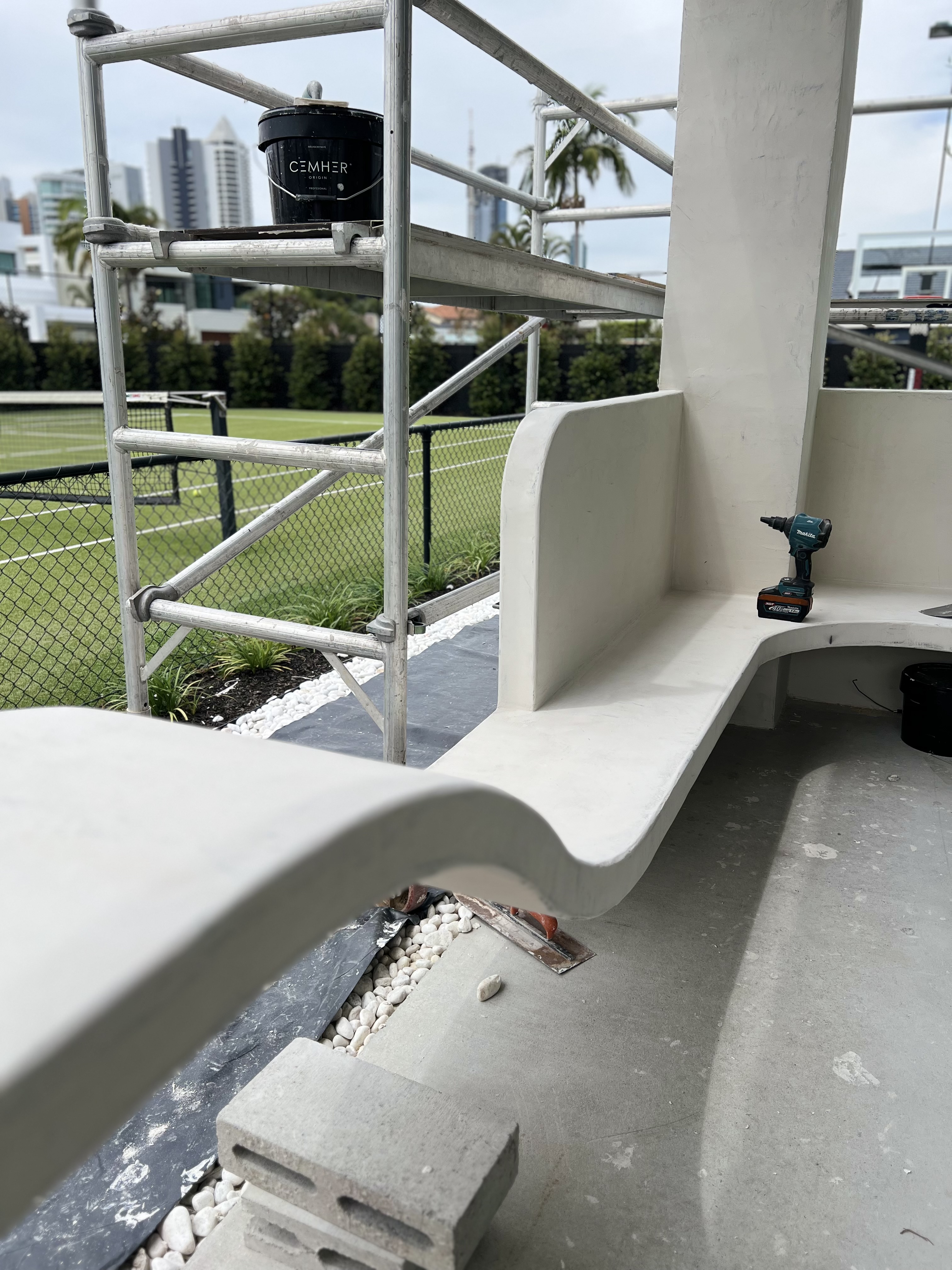 Cemher bucket beside a hand-finished curved microcement bench